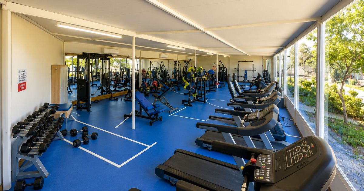 Professional fitness centre with cardio and weight equipment, mirrored walls and garden view, Kemer